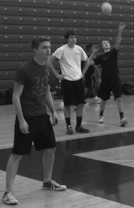 Senior Eric Fleming serves the ball to the players on the other side of the net as seniors Jimmy Klebenow and Keith Carlton wait to send it back over.