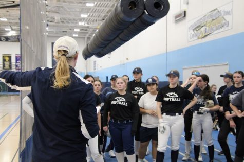  Coach Miller instructs her team on how to warm up after school on March 8. (Pictured left) Catcher Katie Nichols, junior, strengthens her defense.