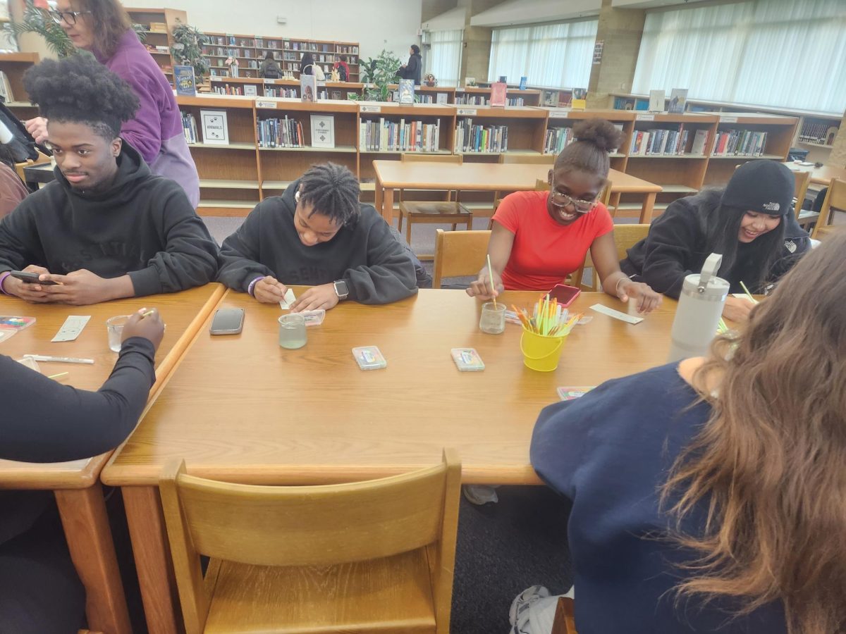 Students painting the watermark bookmarks in the media center/
